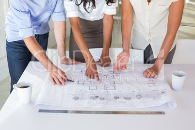 Group of architects working on blueprints