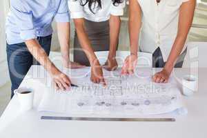 Group of architects working on blueprints