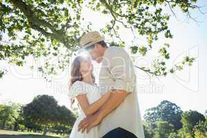 Cute couple standing in the park embracing