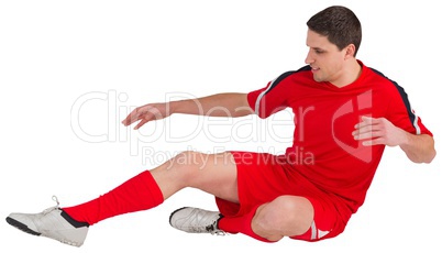 Fit football player jumping and kicking