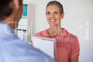 Casual smiling businesswoman looking at colleague