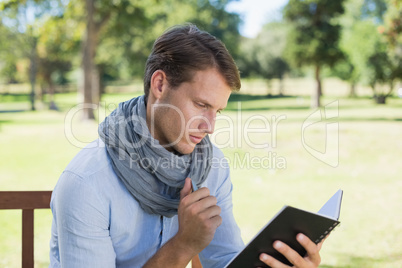 Stylish young man writing in his notepad