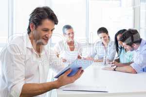 Attractive businessman using tablet at work