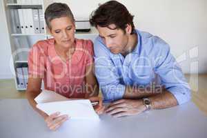 Casual smiling business team working at desk reading document