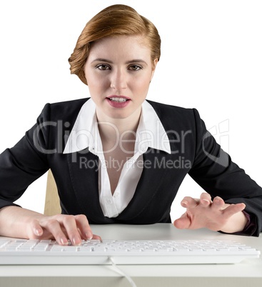 Redhead businesswoman sitting at desk typing