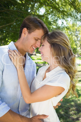 Cute couple hugging in the park and smiling at each other