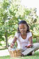 Little girl sitting on grass counting easter eggs