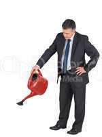 Mature businessman watering with red can