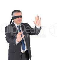 Mature businessman walking with blindfold