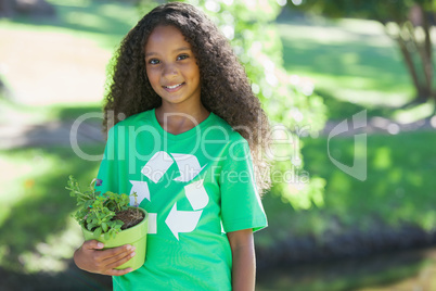 Young environmental activist smiling at the camera holding a pot