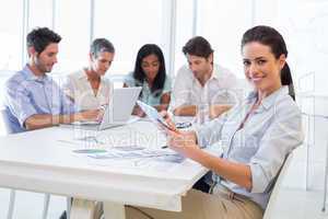 Pretty businesswoman using tablet device in business meeting