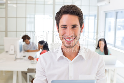 Businessman with tablet pc smiles to camera