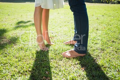 Couples bare feet standing on grass