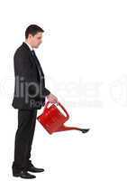Businessman watering with red can