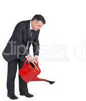 Mature businessman watering with red can