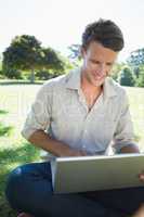 Stylish man using his laptop in the park