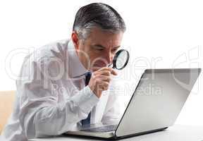 Mature businessman examining with magnifying glass