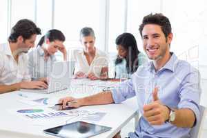 Attractive businessman smiling in the workplace