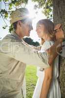 Cute couple leaning against tree in the park