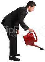 Businessman watering with red can