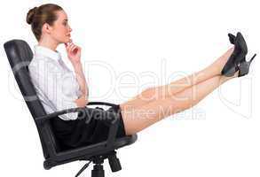 Businesswoman sitting on swivel chair with feet up