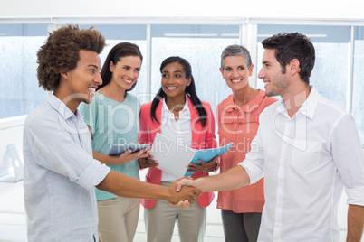 Attractive businessmen shaking hands at work