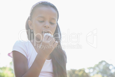 Little girl sitting on grass eating