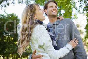 Cute couple embracing and laughing in the park