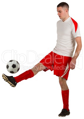 Fit football player playing with ball