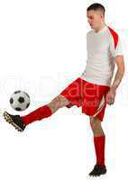 Fit football player playing with ball