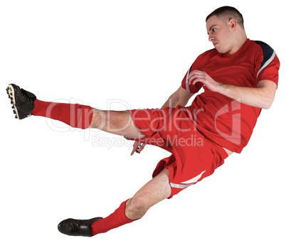 Fit football player playing and kicking