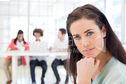 Attractive office worker thinking and looking at camera