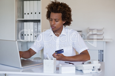 Relaxed casual businessman shopping online at his desk