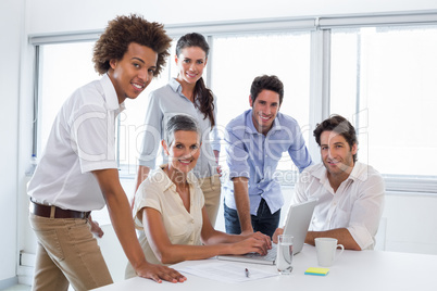 Business people working with laptop and smiling at camera