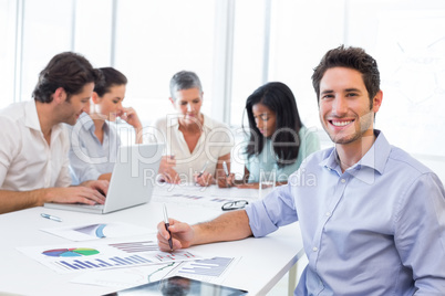 Handsome businessman smiling at the workplace