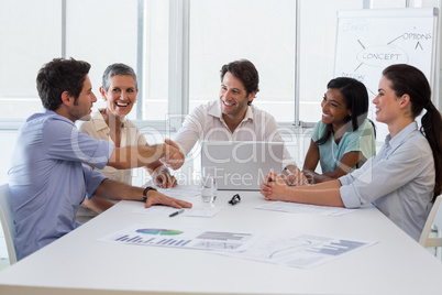 Handsome coworkers shaking hands in approval