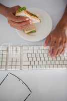 Businesswoman eating a sandwich at her desk