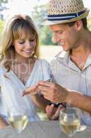 Man placing engagement ring on fiancees finger