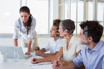 Business people using laptops and notebooks in meeting Business people using laptops and notebooks in meeting