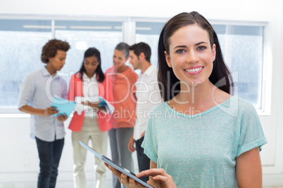 Businesswoman using tablet and smiling at camera