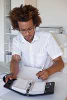 Casual young businessman organizing his schedule at his desk