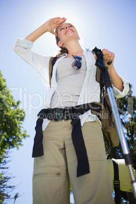 Fit woman standing with hiking pole in park