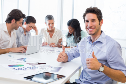 Attractive businessman smiling in the workplace