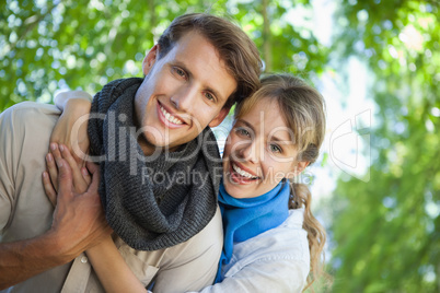 Cute couple smiling at camera in the park