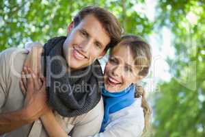 Cute couple smiling at camera in the park