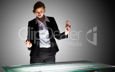 Redhead businesswoman standing and gesturing by a desk Redhead businesswoman standing and gesturing by a desk