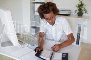 Casual young businessman organizing his schedule at his desk