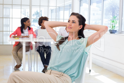 Attractive office worker relaxing with colleagues working behind