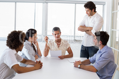 Serious businesswoman speaking to her coworkers