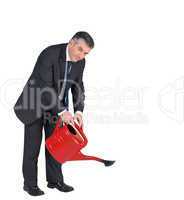 Mature businessman watering with red can